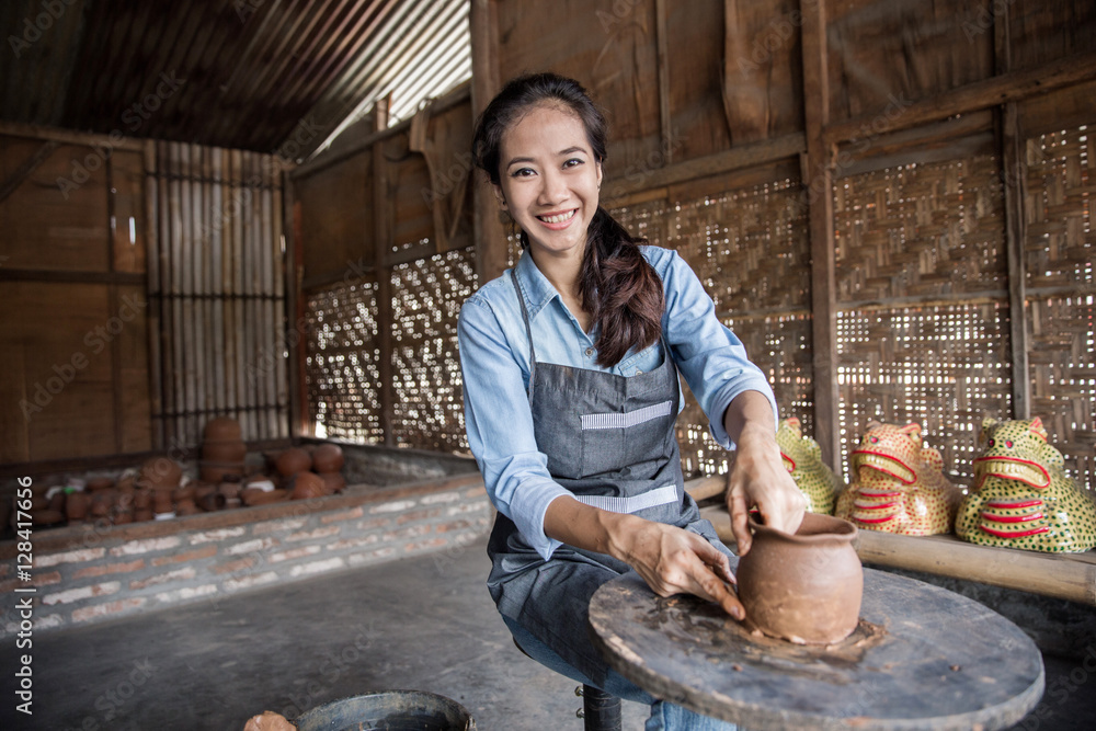 female potter making pot