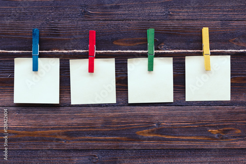 note paper and colorful cloth peg on wooden background