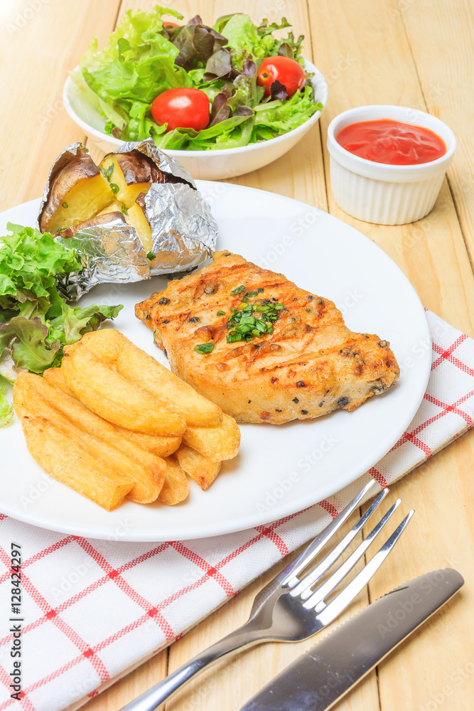 Grilled meat steak serve with tomato sauce, Mashed Potatoes, french fries and vegetable salad, isolated on wooden background, Closed up