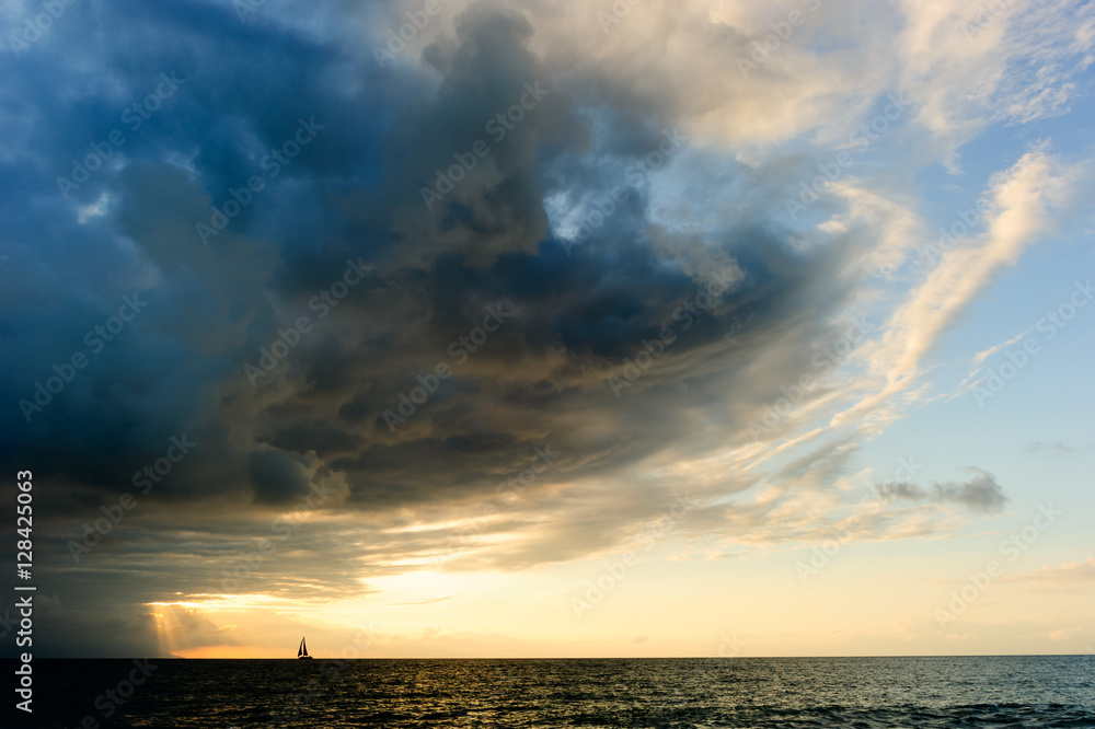 Fototapeta premium Ocean Storm Sailboat Sunset Approaching Looming Dramatic Hope Faith Sky