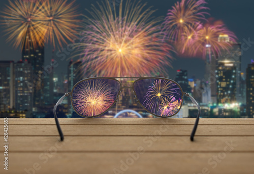 Obraz na płótnie Fireworks focused in glasses lenses on the wooden over the abstr w salonie