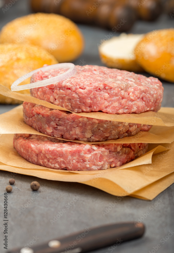 Close up raw ground beef meat cutlets with onion ring Close up raw ground beef meat cutlets with onion ring