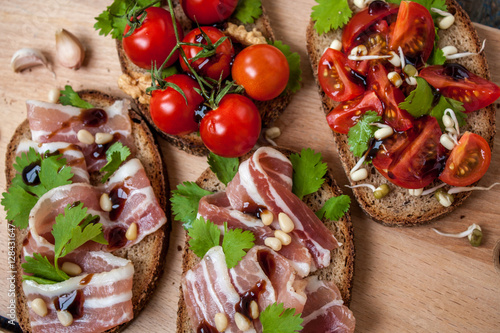Snack of bread (baguette), bacon (ham), tomatoes, balsamic and spices. Good beer and wine. Love for a European healthy raw food concept.