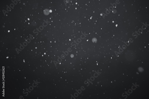 Falling snow on black background.