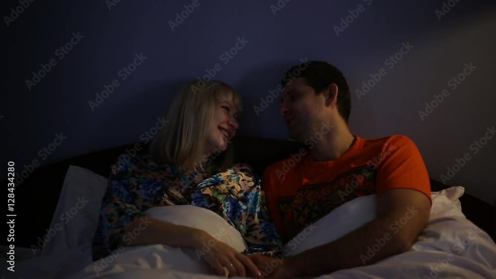 Couple talking in bed. Man and woman in the bedroom at night. Lovers ...