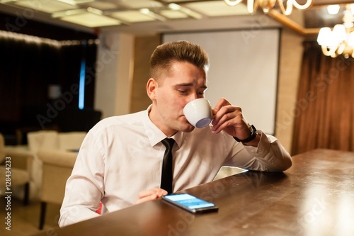 Young people drinking coffee and watching the phone