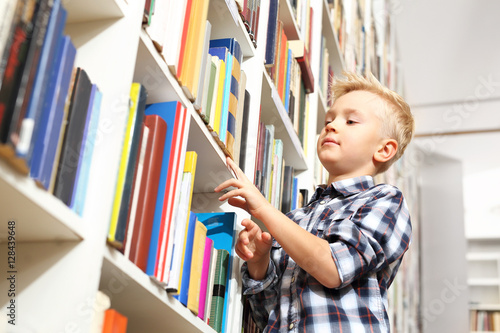 Biblioteka. Chłopiec wybiera książkę  photo