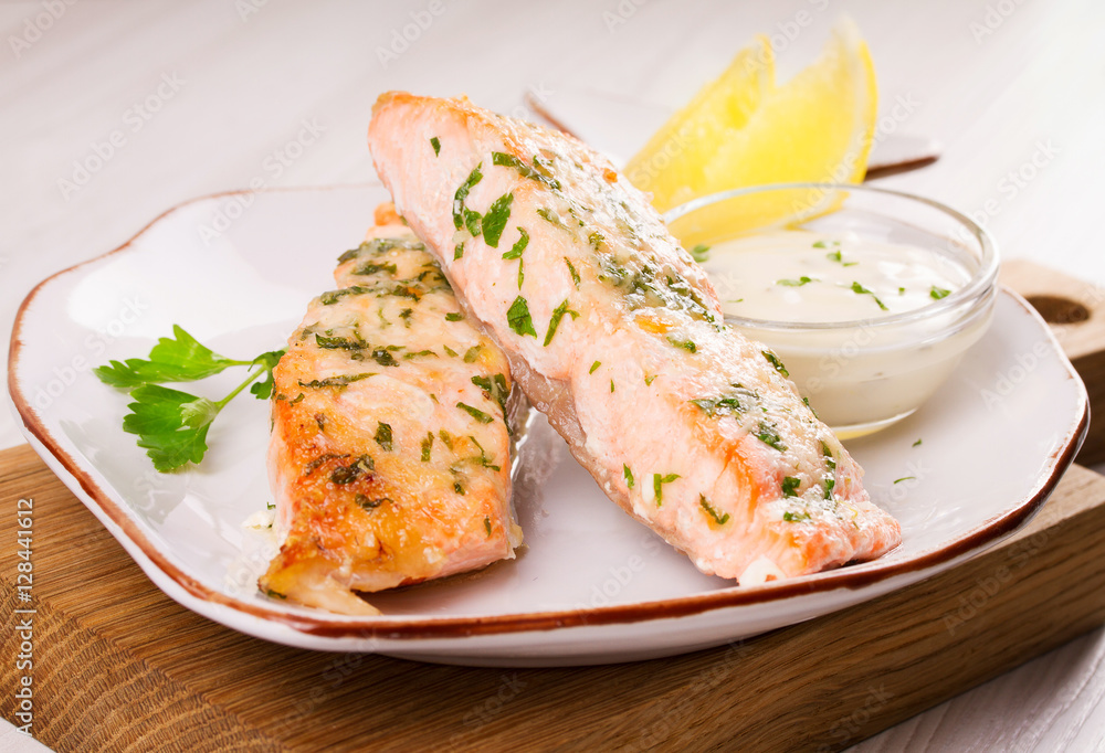 Baked salmon with parmesan and herbs, lemon and sauce.