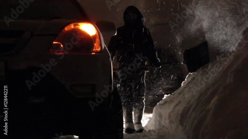 Car stuck in the snow. Paralyzed the movement of vehicles. Driver cleans the road from snow