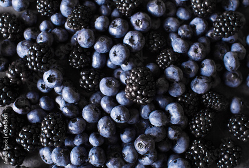 Blackberries, blueberries a gray abstract background. Copyspace. Healthy food concept.  Colorful festive still life. Loosely laid berries in different positions