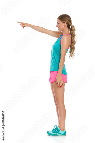 Girl In Sports Clothes Pointing. Side View Isolated.