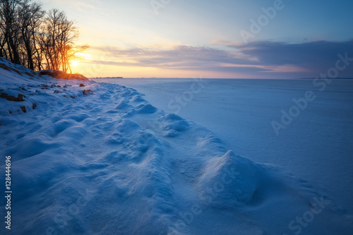 Beautiful winter landscape with sunset sky and frozen lake © es0lex