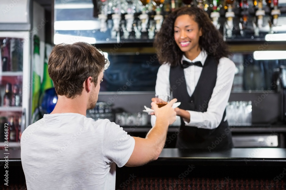 Barmaid serving drink to man Barmaid serving drink to man
