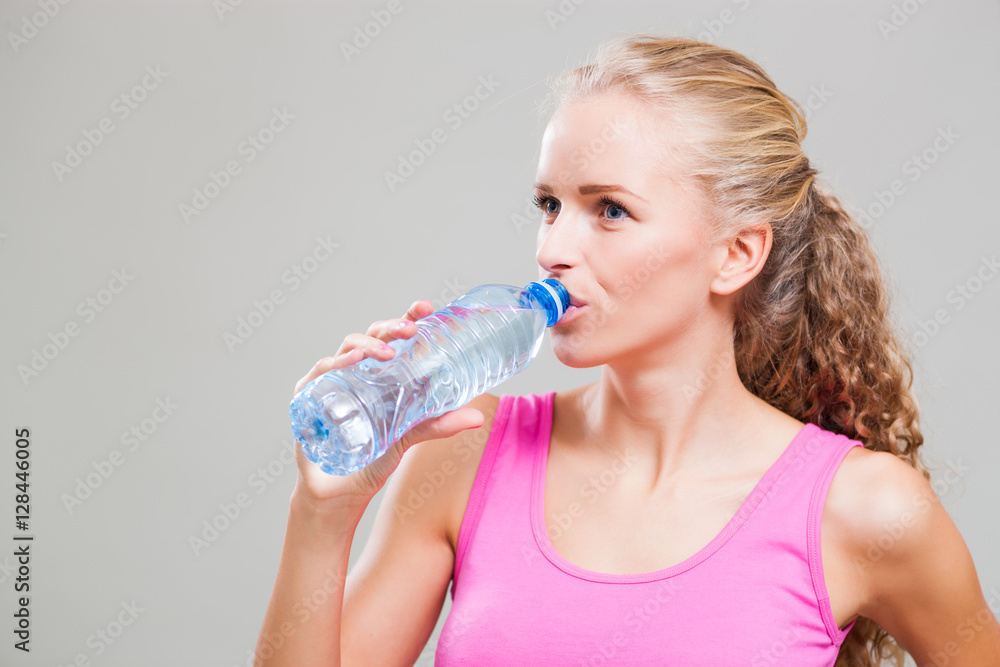 Studio shot image of young sporty woman who is drinking water. Studio shot image of young sporty woman who is drinking water.
