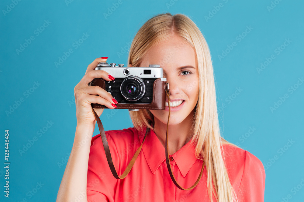Portrait of a smiling young blonde girl holding photo camera Portrait of a smiling young blonde girl holding photo camera