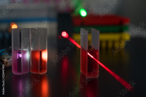 Quartz cuvette for laser chromatography with red liquid. Physical chemistry laboratory photo
