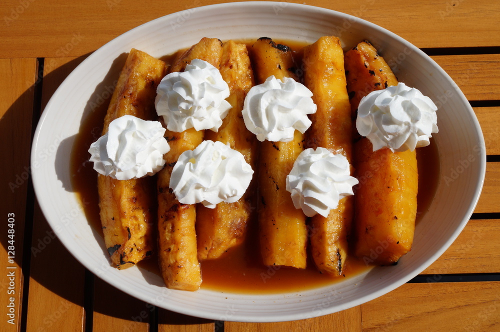 Slices of roasted caramelized pineapple with whipped cream