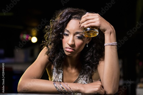 Depressed woman having beer at whiskey counter