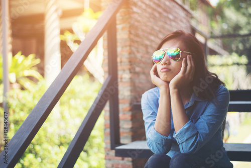 Young hipster woman sitting on staircase while looking away to o photo