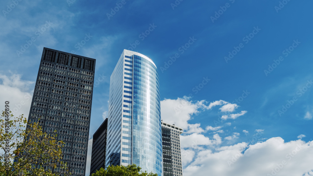 Two modern office buildings against the sky and clouds drifting fast. 