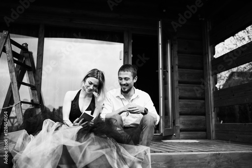 Beautiful stylish couple rest near the house b&w