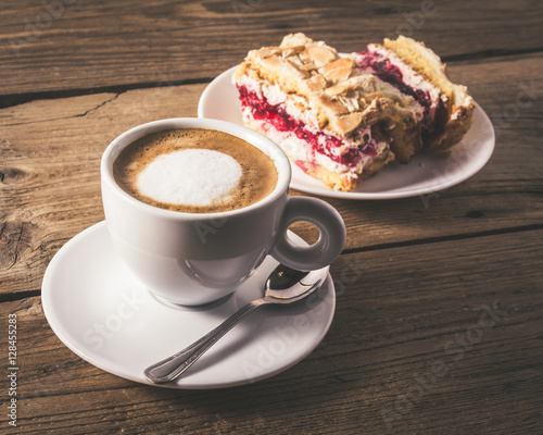 cake with raspberries and cup of coffee on a wooden table
