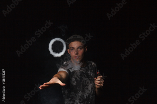 man smoking electronic cigarette lets rings of smoke