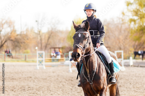 Small rider girl on show jumping competition