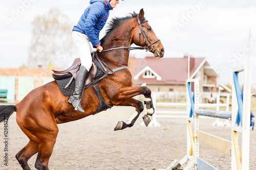 Young horseman on show jumping competition © skumer