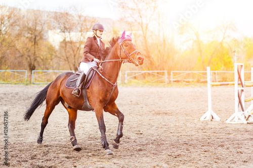 Young rider woman riding horse at the competition