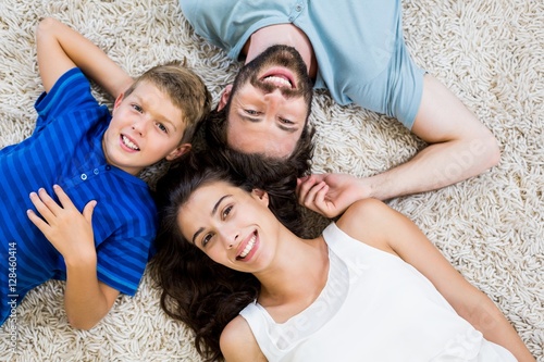 Portrait of parents and son lying on rug