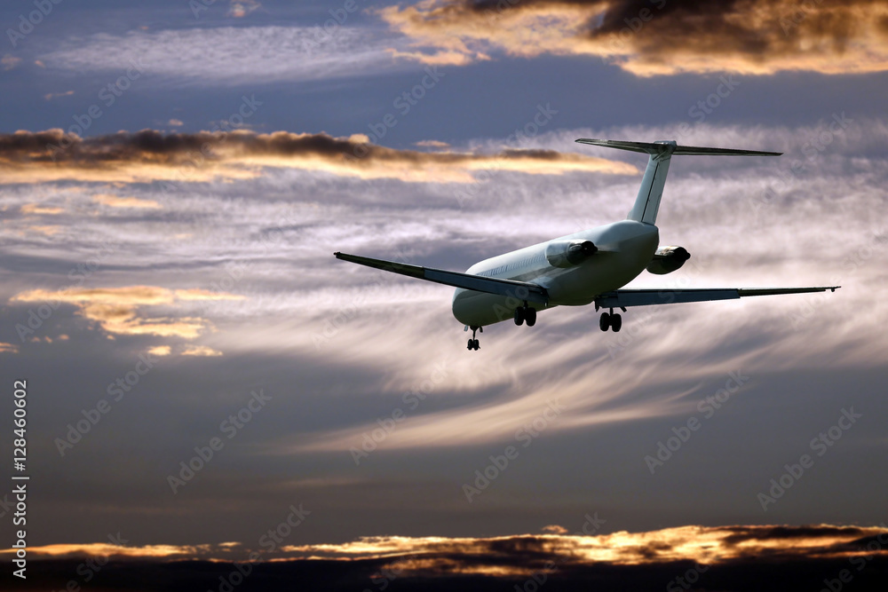 passenger jet plane flying in the evening sky at sunset