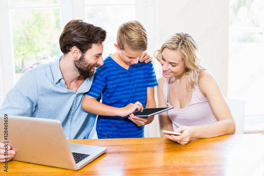 Parents and son using a laptop, tablet and phone Parents and son using a laptop, tablet and phone