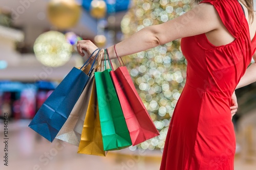 Christmas shopping concept. Young woman holds many colorful shopping bags.