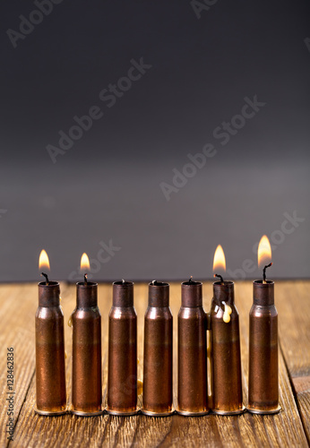 Burning candles and empty rifle cartridges.