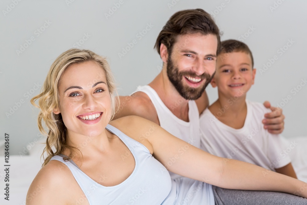 Portrait of parents and son sitting on bed in bedroom Portrait of parents and son sitting on bed in bedroom