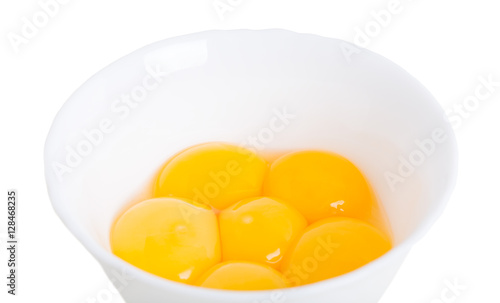 Fresh egg yolks on white bowl.