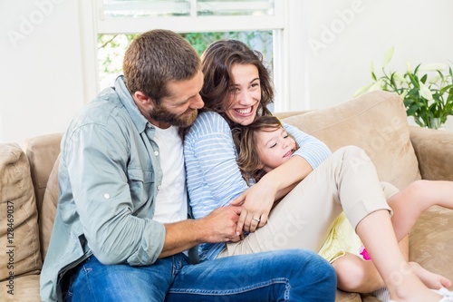 Parents sitting on sofa with daughter © WavebreakMediaMicro