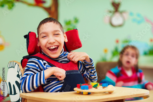 cheerful boy with disability at rehabilitation center for kids with special needs photo