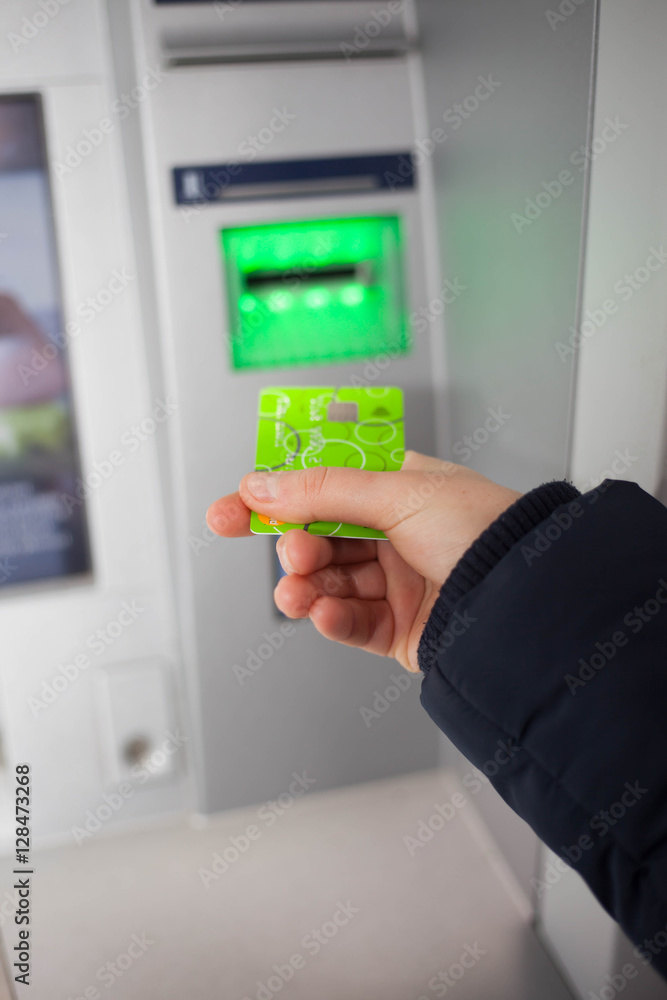Woman hand using credit card to withdraw money from ATM (color t Woman hand using credit card to withdraw money from ATM (color t