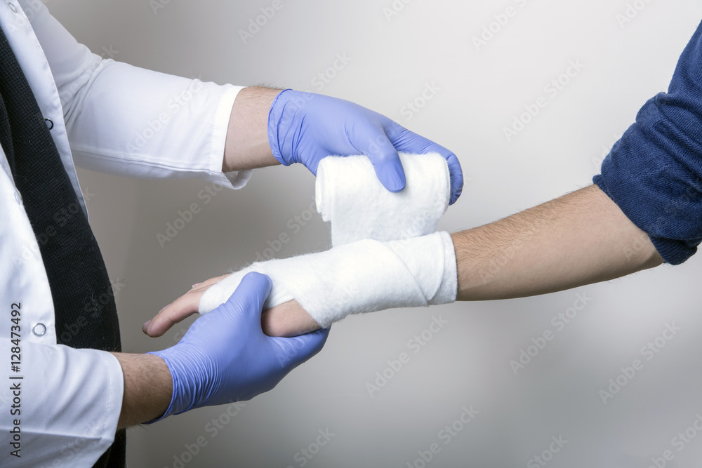 Pediatrician wrapping wrist of patient during exam Pediatrician wrapping wrist of patient during exam