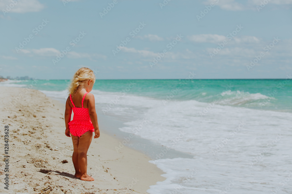 little girl going to swim at beach