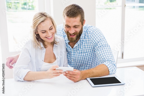 Smiling couple using a mobile phone