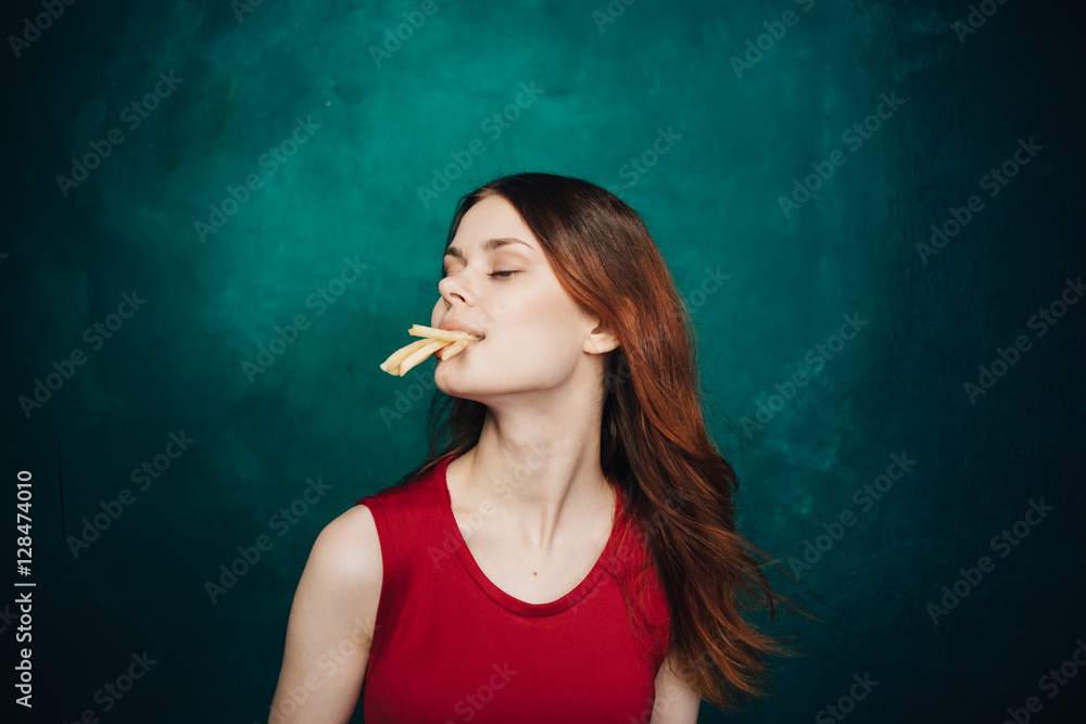 Fototapeta premium Pretty women eating a lot of potatoes fries. Happiness from food. 
