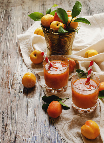 Fresh apricot juice in glass on wooden table, selective focus