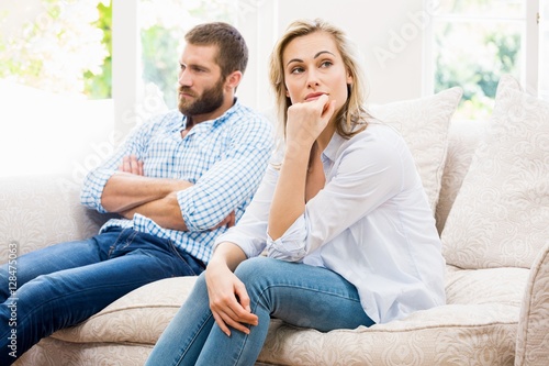 Картината върху платно Young couple ignoring each other in living room