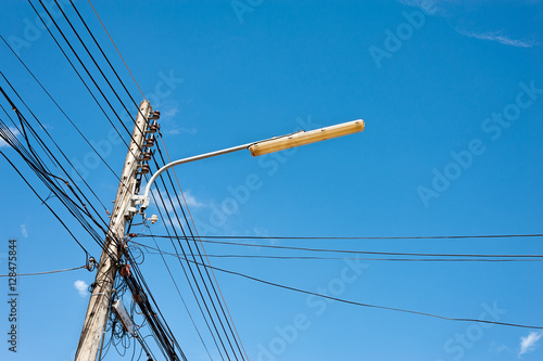 Power lines and lamp with blue sky.