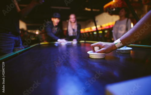 Fotografie, Obraz Young friends playing air hockey game