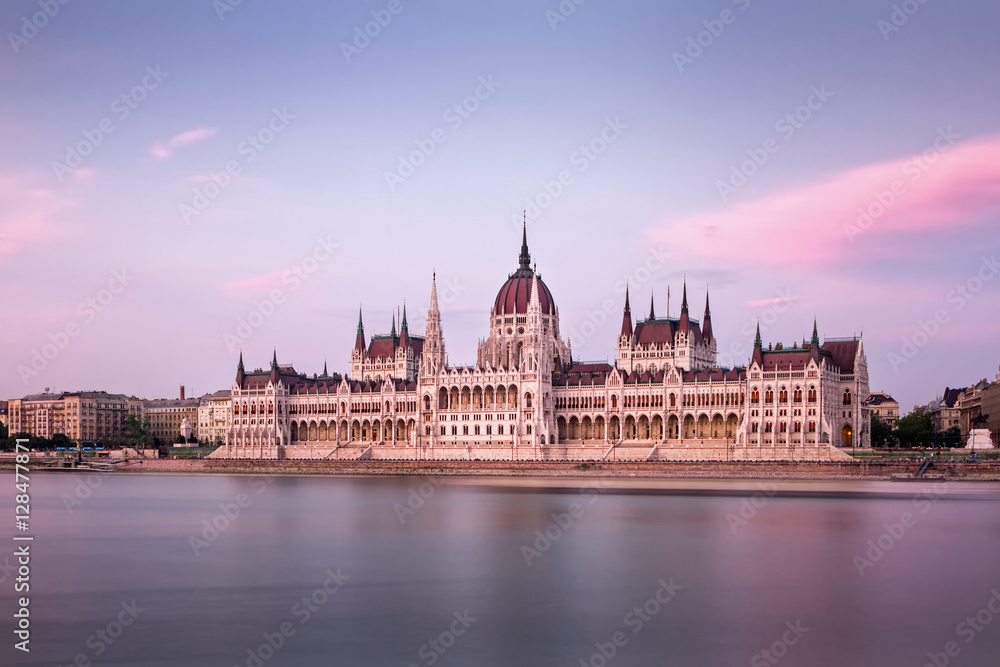 Obraz premium The Hungarian Parliament on the Danube riverbank at nightfall