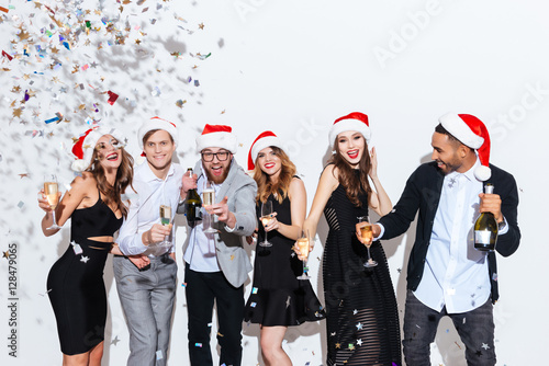 Group of cheerful friends with champagne celebrating new year together